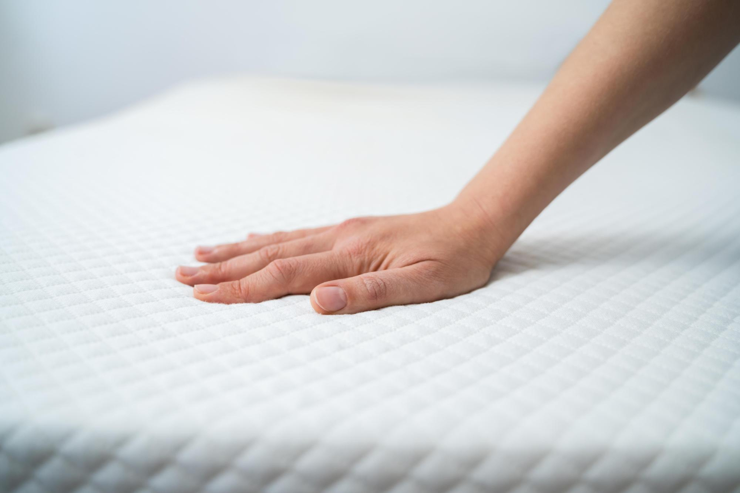 jeune femme testant le moelleux d'un matelas